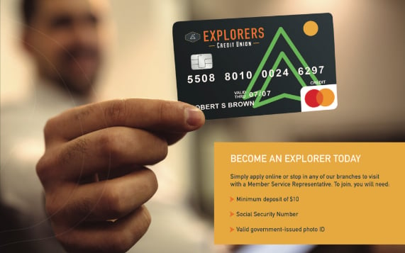 An adult male holding an Explorers Credit Union credit card.